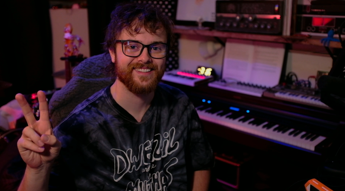 Simon in the studio throwing a peace sign